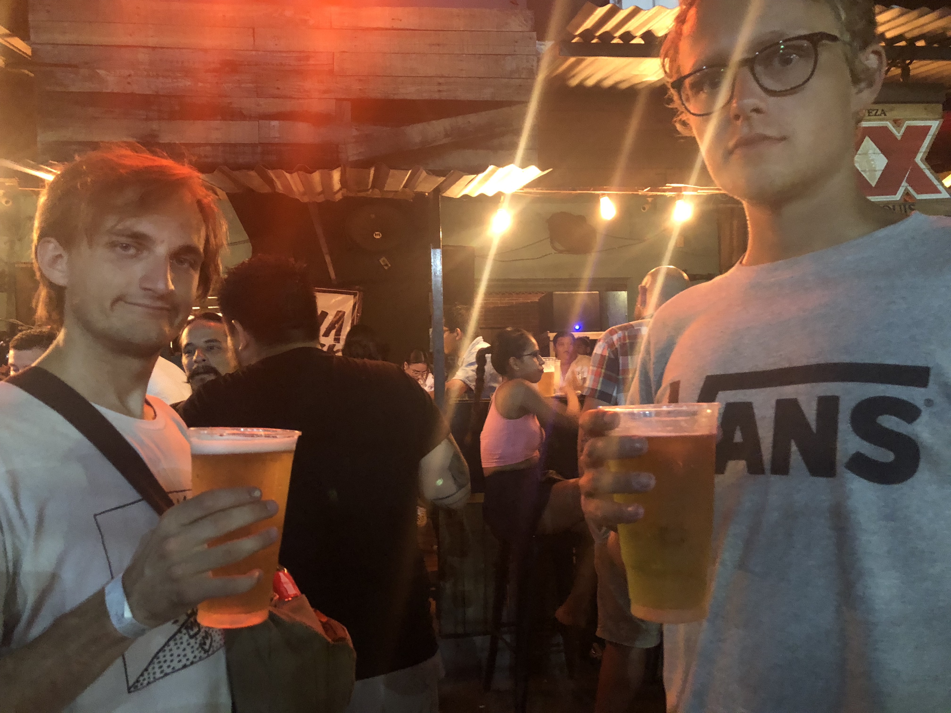 Two men holding a litre of beer each.